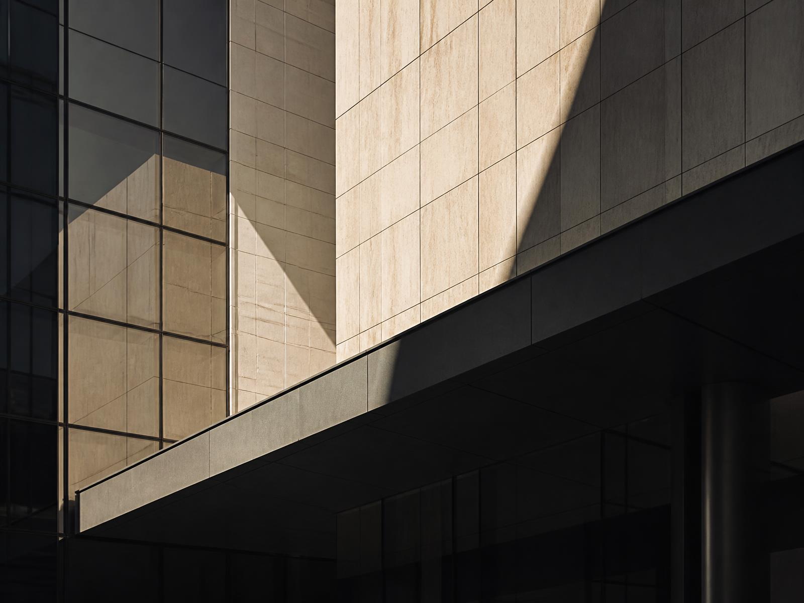 Sunlit stone and glass facade of a corporate building